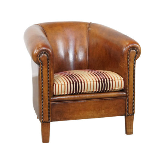 Cognac-kleurige, Karaktervolle Vintage Schapenleren Clubfauteuil Met Een Kleurrijk Stoffen Kussen 1