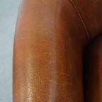 Schapenleren Clubfauteuil In Een Charmante Cognac Kleur En Afgewerkt Met Biezen Op De Rugleuning thumbnail 8