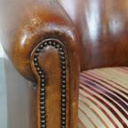 Cognac-Kleurige, Karaktervolle Vintage Schapenleren Clubfauteuil Met Een Kleurrijk Stoffen Kussen thumbnail 11