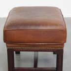 Hocker Gemaakt Van Schapenleer Met Een Houten Frame En Een Afwerking Met Siernagels thumbnail 4