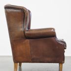 Comfortabele En Stoere Oorfauteuil Gemaakt Van Schapenleer En Strak Afgewerkt Met Zwarte Biezen thumbnail 4